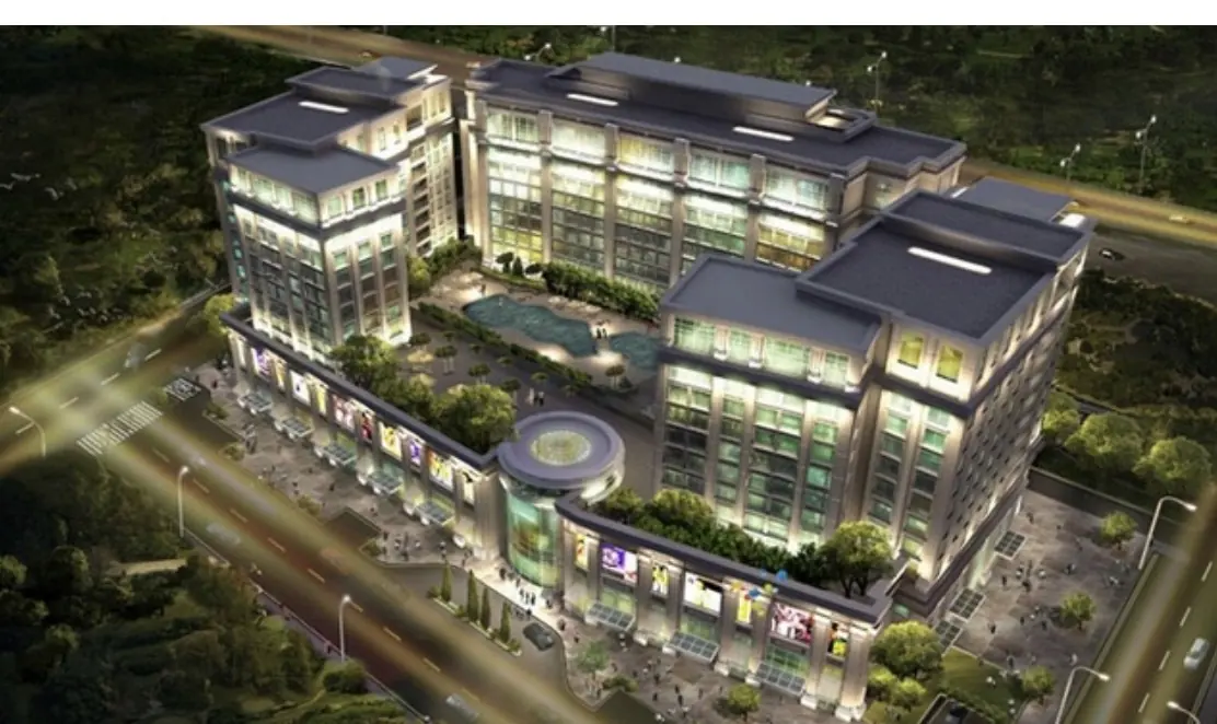 Aerial view of the Pace Circle mixed-use building at night, with lit terraces around a central courtyard.